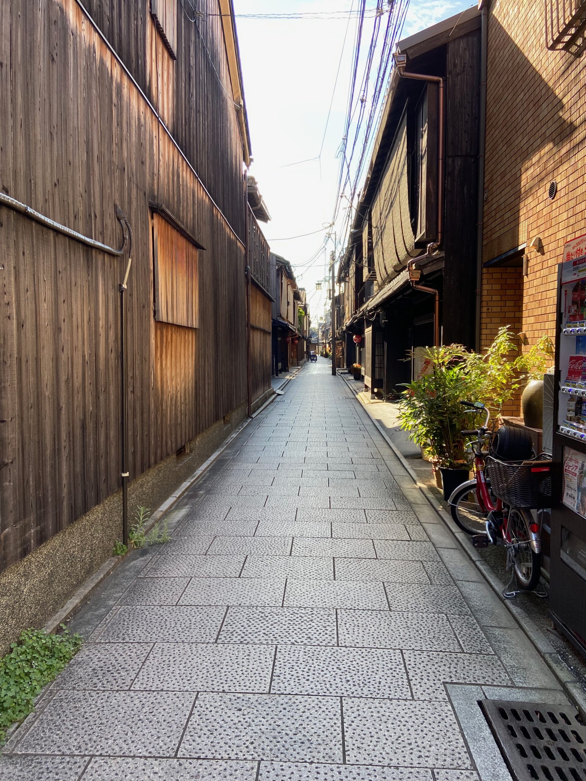 京都の古い町家が並ぶ細い路地。観光地から一歩外れた、暮らしの気配が残る通り