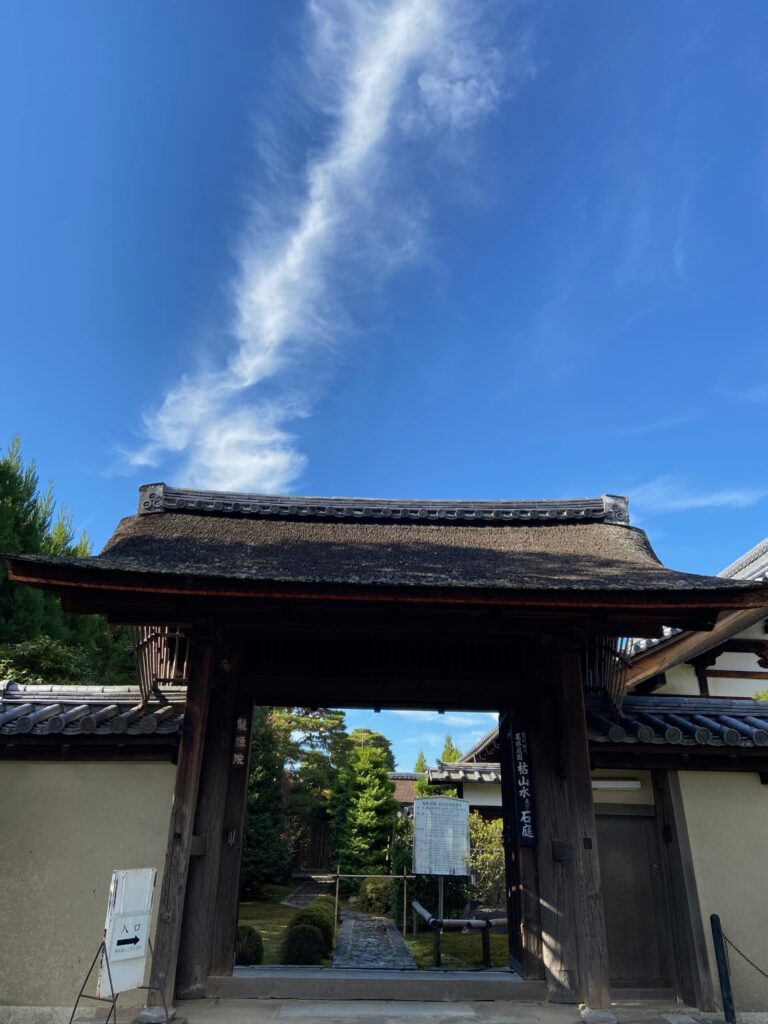 大徳寺の塔頭の門と、青空に立ち上る龍のような雲