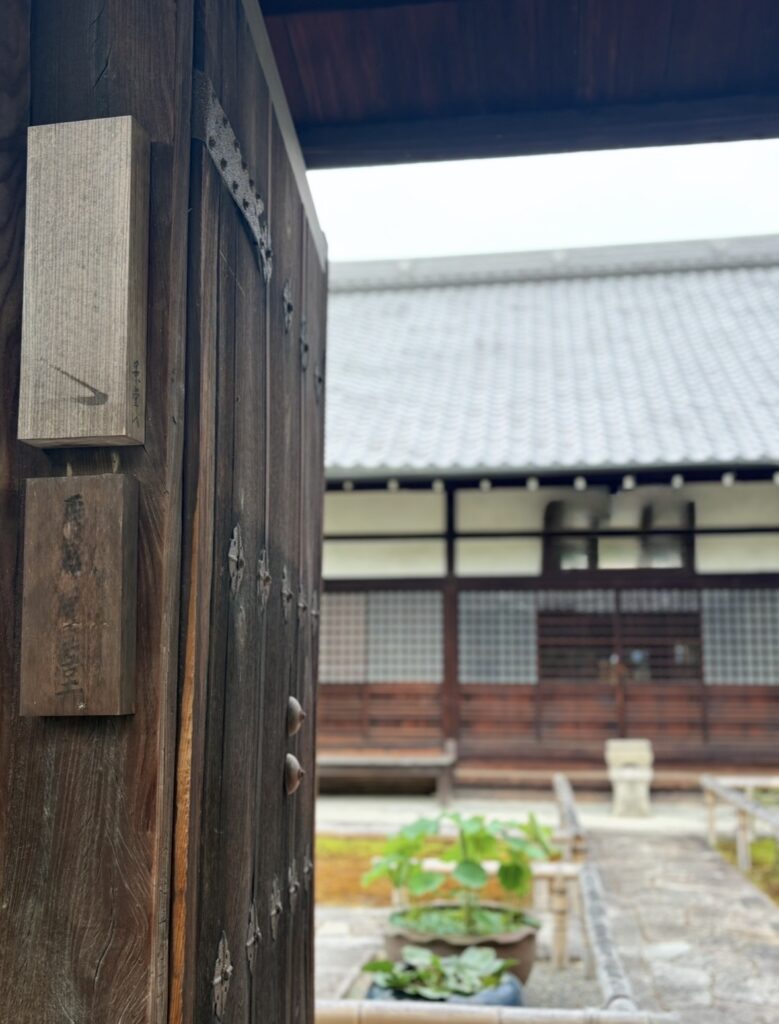 古い門扉と、その奥にのぞく中庭