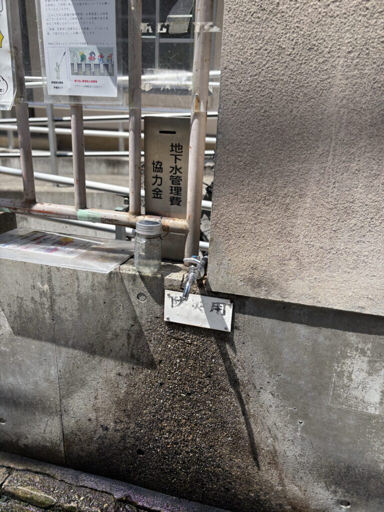 銅駝水の蛇口。地下水管理費の協力金箱とともに