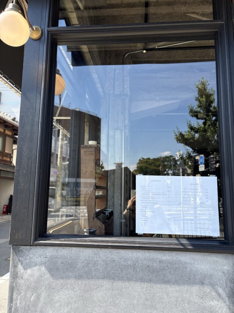 ドゥージィエムメゾンの窓辺。ガラスごしに映る店内とランプ