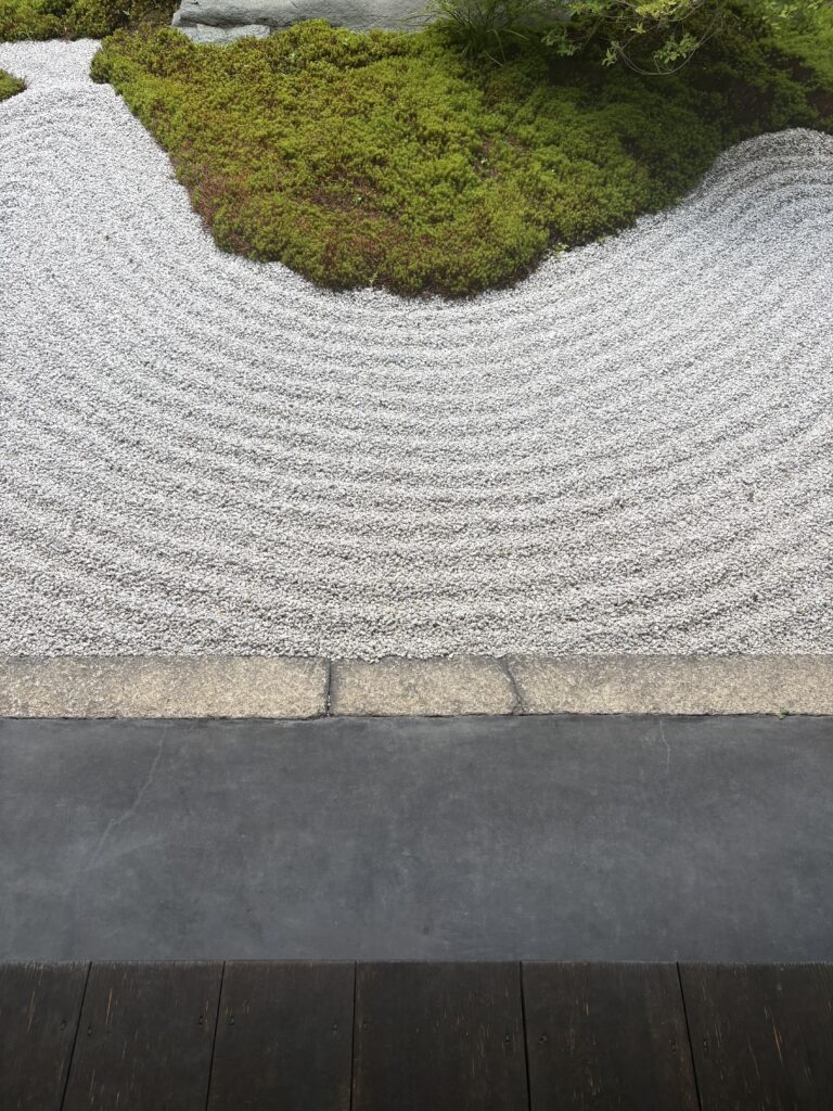 塔頭の庭。白砂利に描かれた波紋と、青い苔