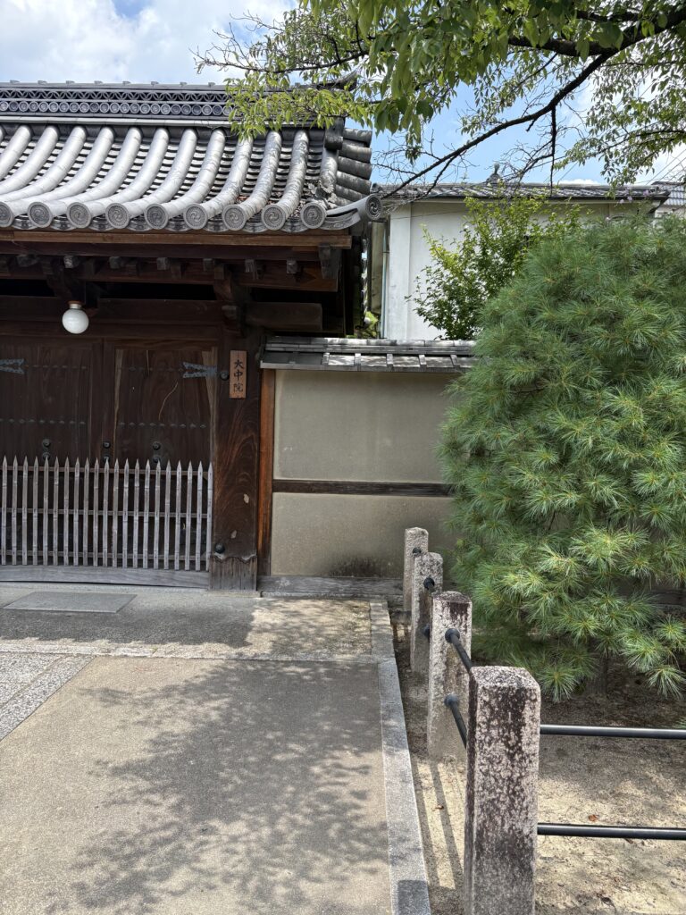 相国寺の塔頭の門。瓦屋根と白壁、傍らに松