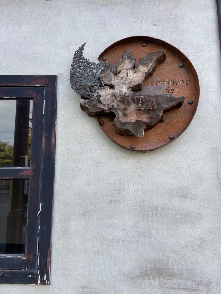 鉄の円盤に木を組んだ、手仕事の店の看板