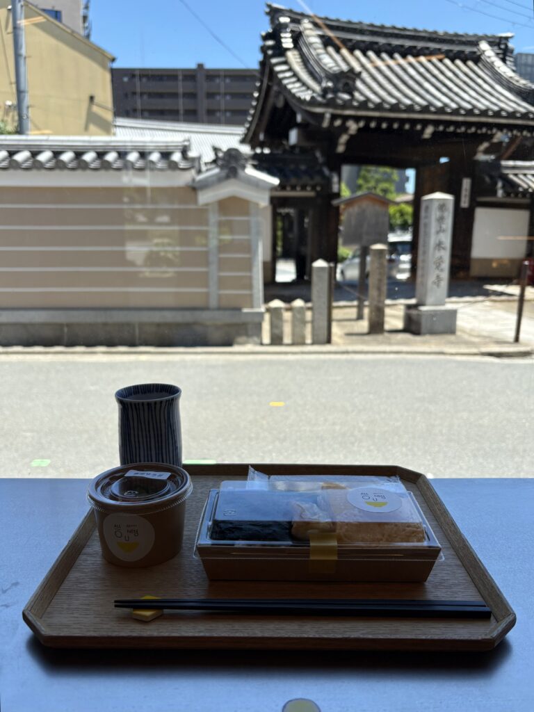 アロウネノのだし巻き卵入りお弁当。窓の外には本覚寺の山門が見える窓辺の席