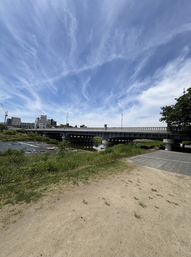 河原の先に橋。空が広い