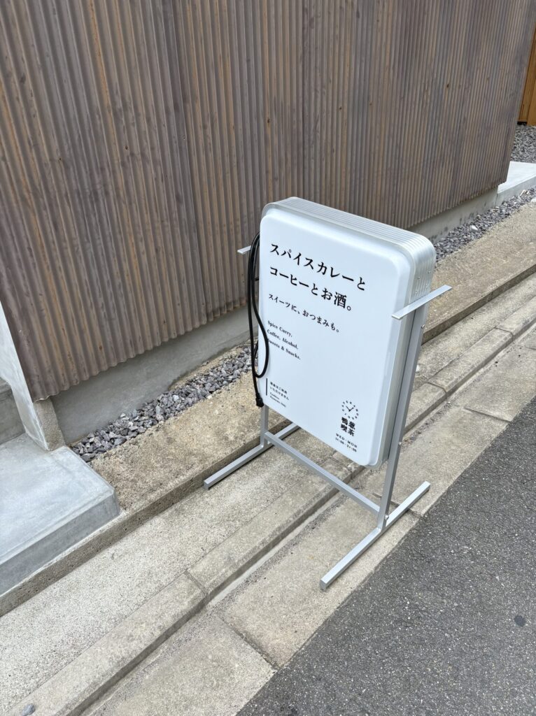 鴨葱喫茶の立て看板。「スパイスカレーと コーヒーとお酒。」の文字
