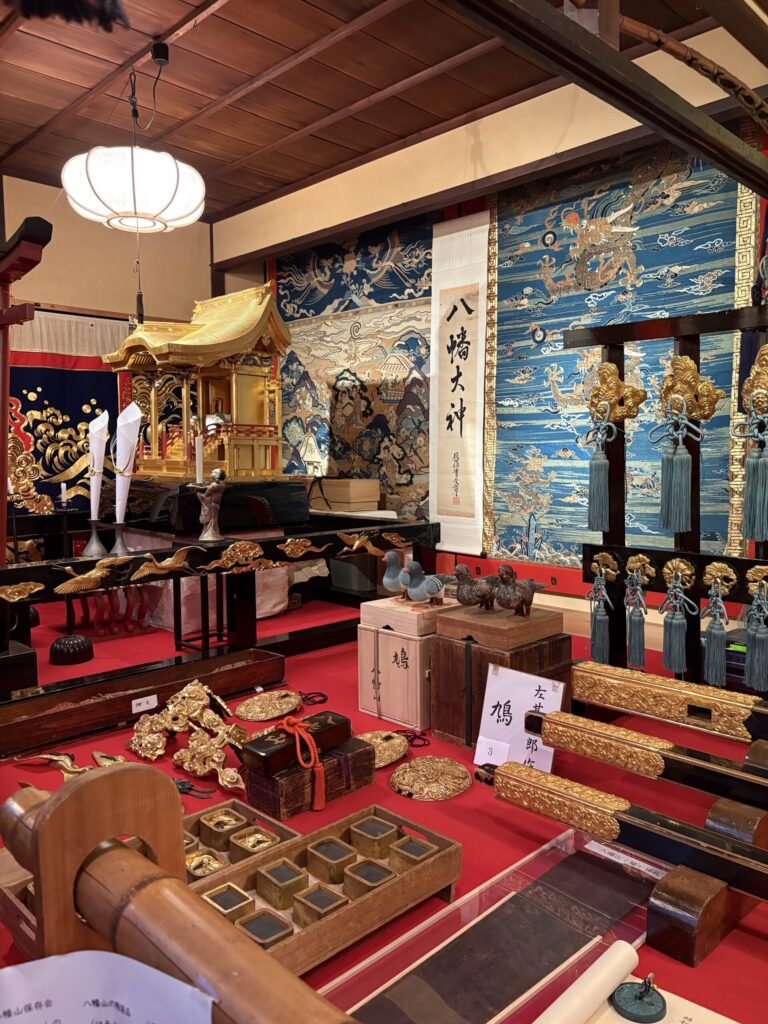 祇園祭 後祭・八幡山の会所飾り全景。金色の八幡宮の社殿と「八幡大神」の掛軸、鳩の置物