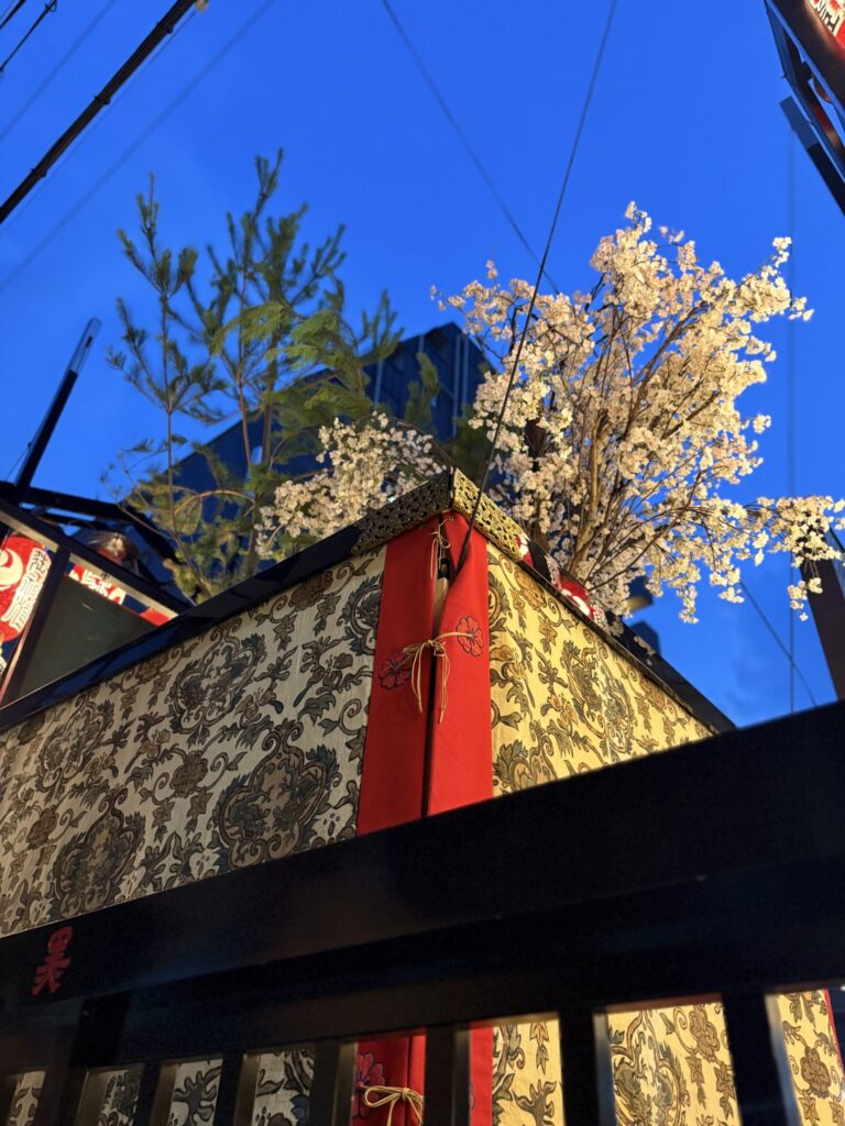 祇園祭 後祭・黒主山を見上げる。屋根の上の真松と桜の花、金襴の水引