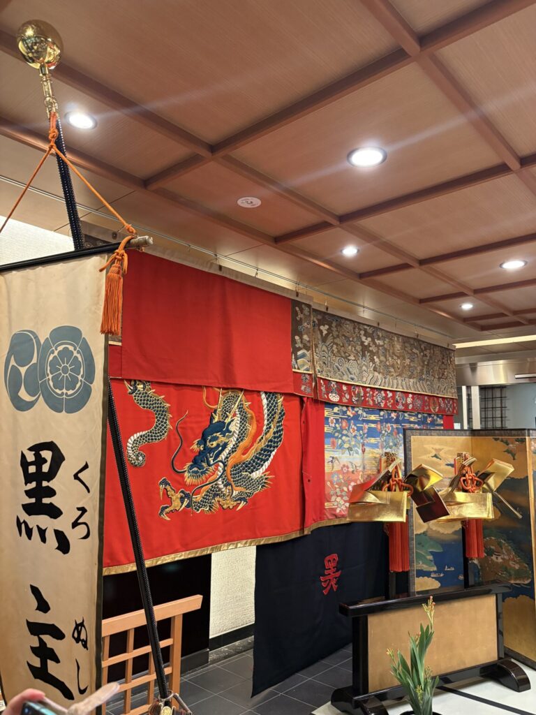 祇園祭 後祭・黒主山の会所飾り。「黒主山」の幟と、赤地に龍を刺繍した幕