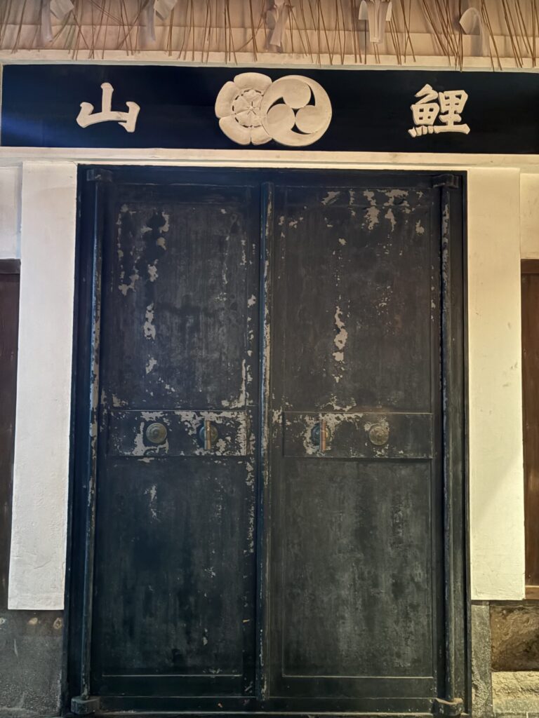 祇園祭 後祭・鯉山の会所。「鯉山」の扁額と注連縄がかかる、古い黒塗りの扉