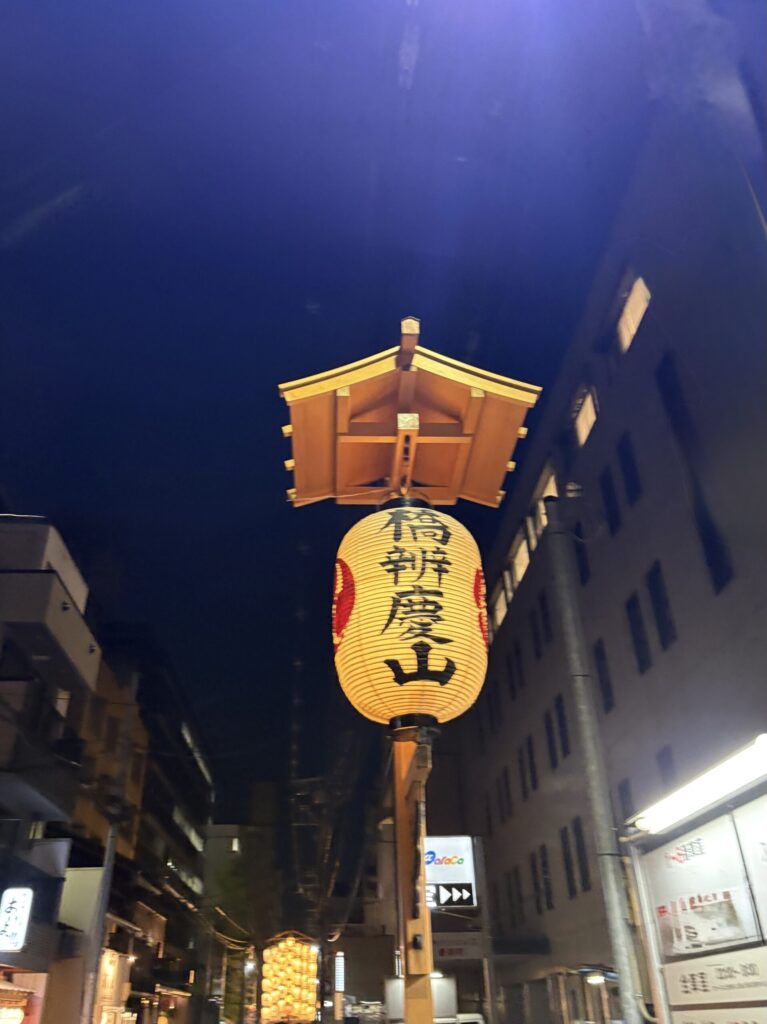 祇園祭 後祭・橋弁慶山の駒形提灯。夜空の下、奥に別の山鉾の灯りが見える