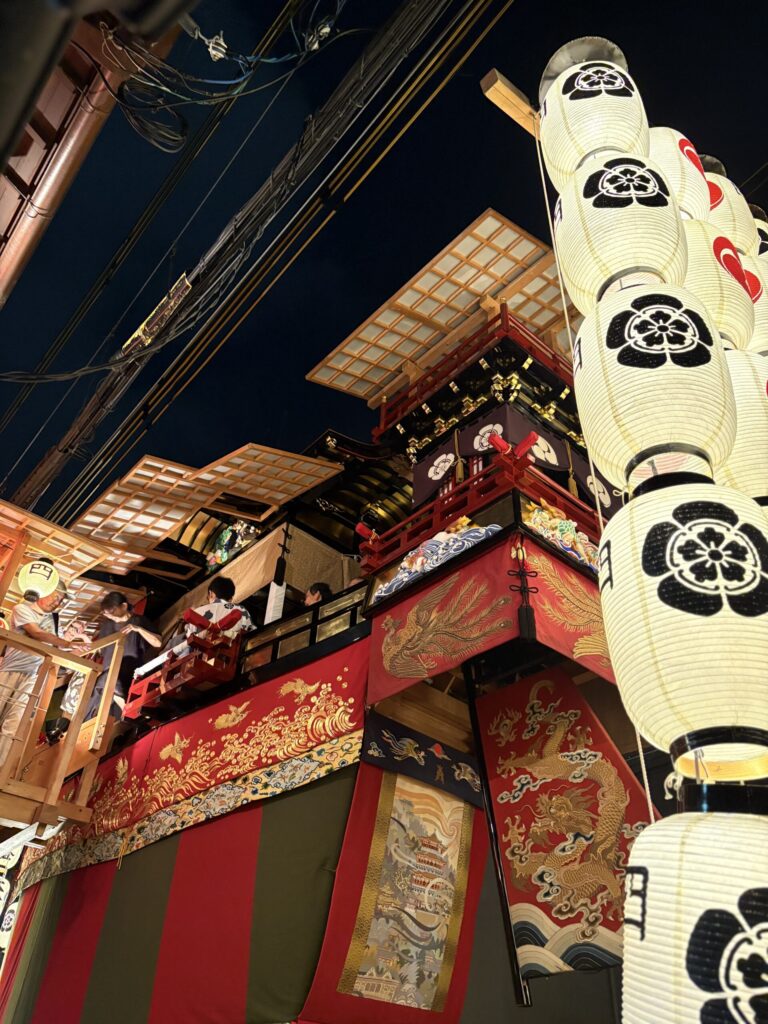 祇園祭 後祭・大船鉾を見上げる。赤い水引に金の龍と鳳凰、鉾の上には囃子方