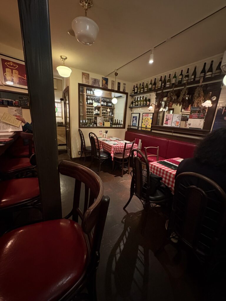 三条新町のフレンチビストロの店内　赤いギンガムチェックのテーブルとワインの棚