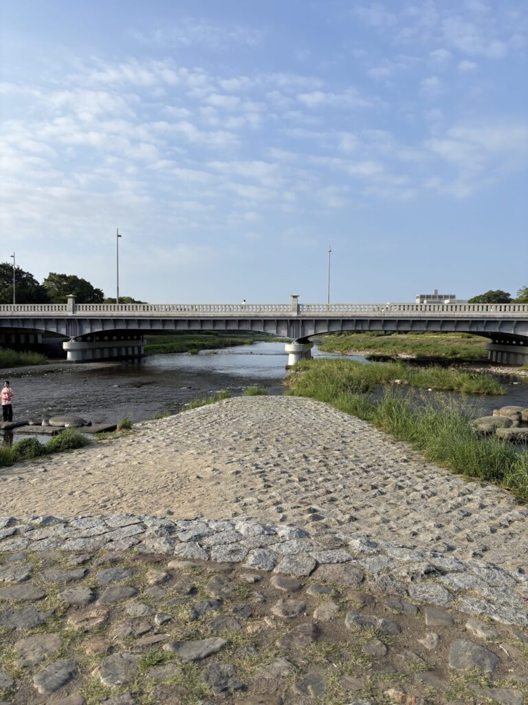 鴨川デルタの先端から見た賀茂大橋。石畳の三角地帯と、朝のうろこ雲
