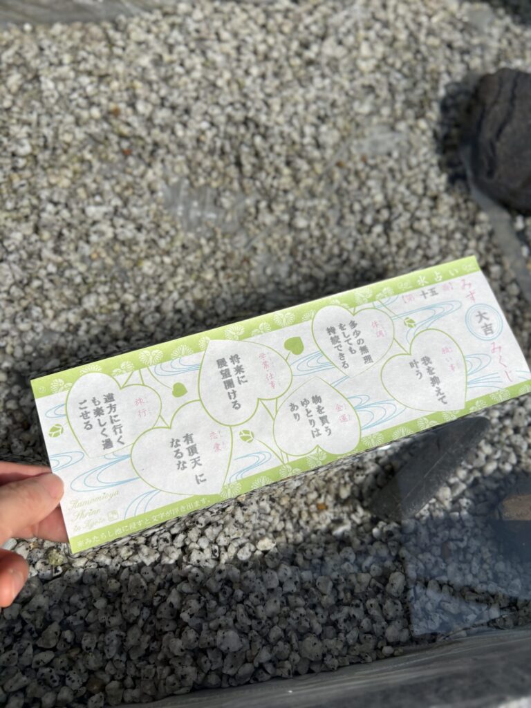 水に浸して文字の浮き出た水占みくじを、水盤の縁で読む
