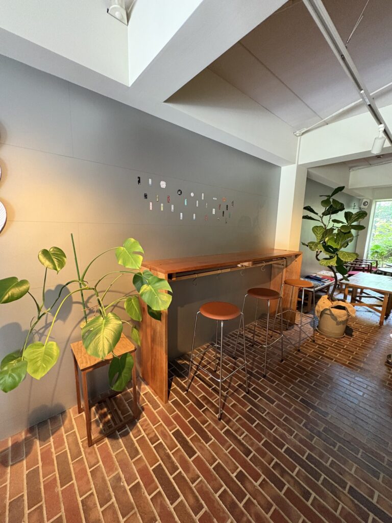 2254 HOTEL & LOUNGEのラウンジ。レンガ敷きの床に木のカウンター、吹き抜けの観葉植物