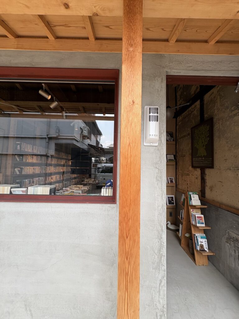 鴨葱書店の軒下。窓ガラスに入った店名のロゴと、「鴨葱書店」と記された白い外灯