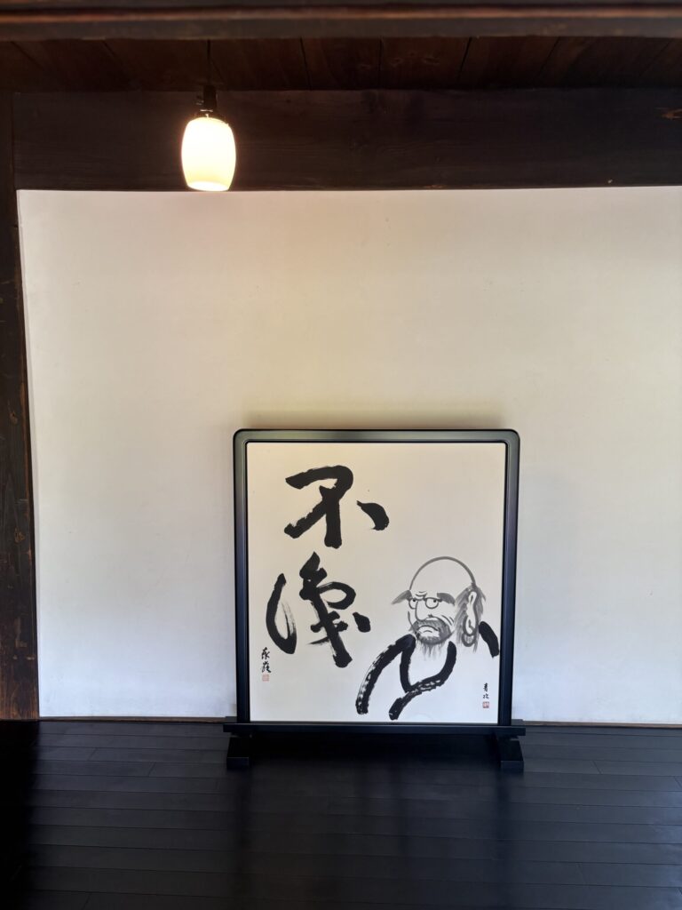 西来院の衝立。「不識」の二文字と、達磨の顔が墨で描かれている
