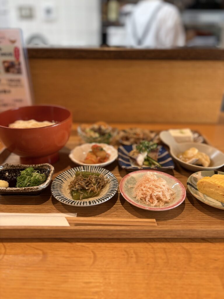ごはんや村上のカウンター席に並ぶ豆皿と、朱の椀