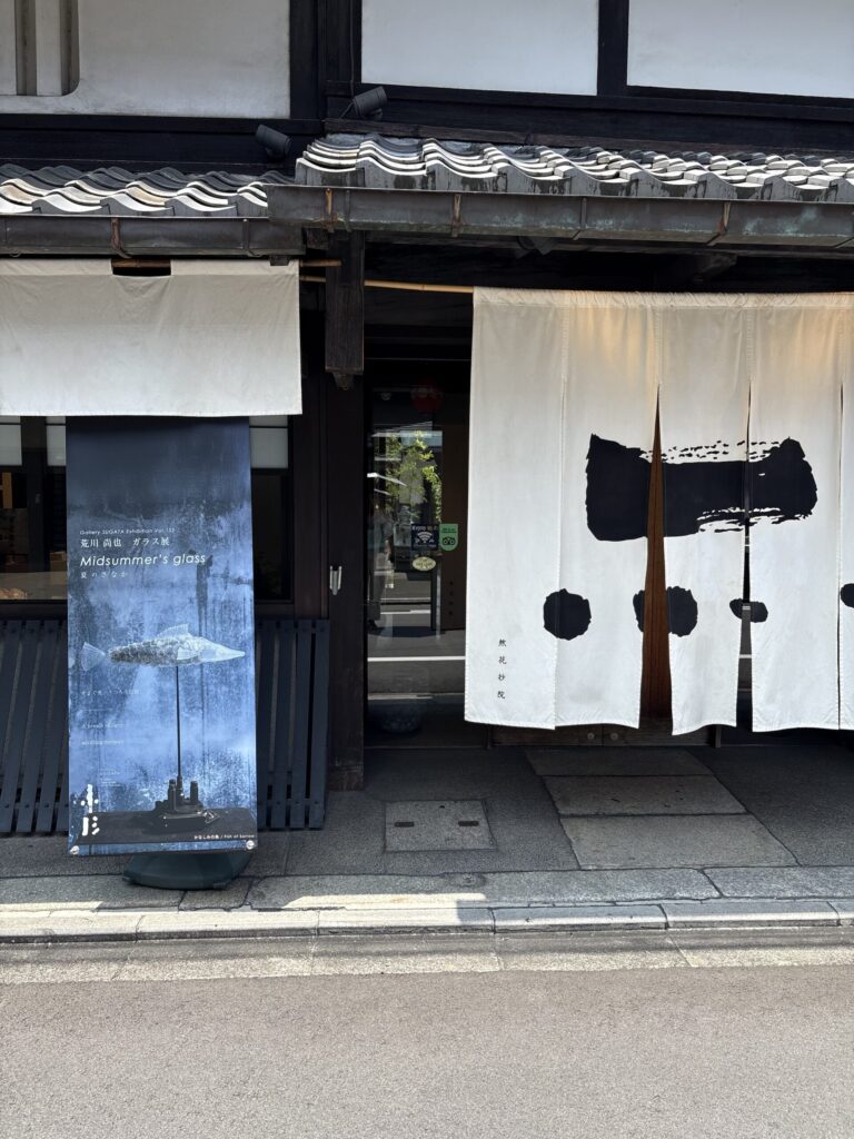 然花抄院の入口。墨の意匠の暖簾と、Gallery SUGATAの案内