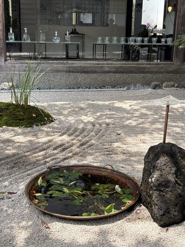 Gallery SUGATAの枯山水。白砂に睡蓮の鉢と、挿されたガラス