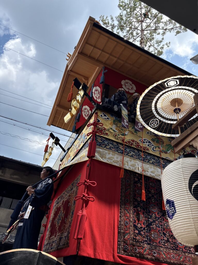 鷹山の囃子方。「鷹」の房を下げて、帰り道の屋根に並ぶ