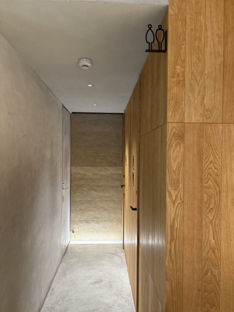 京都小川生薬の館内　木の壁と土壁がつづく通路の奥の階段