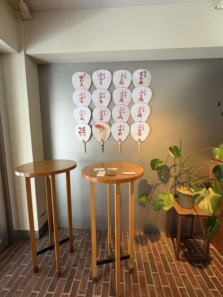宮川町2254のラウンジの壁に並ぶ、芸妓・舞妓の名前入り団扇。京都ひとり旅で立ち寄った町家のカフェ