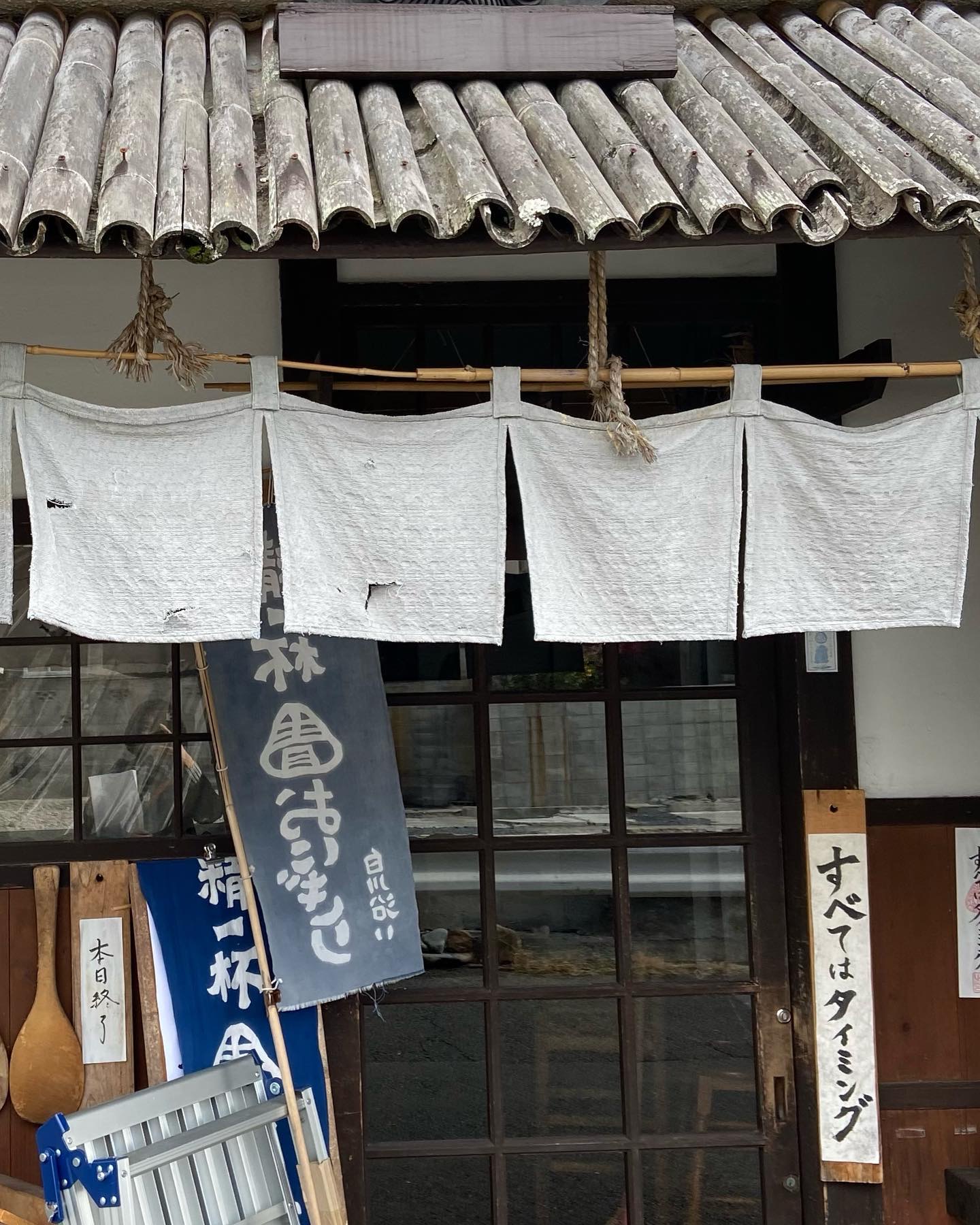 青おにぎりの入口に掛かる「すべてはタイミング」の札
