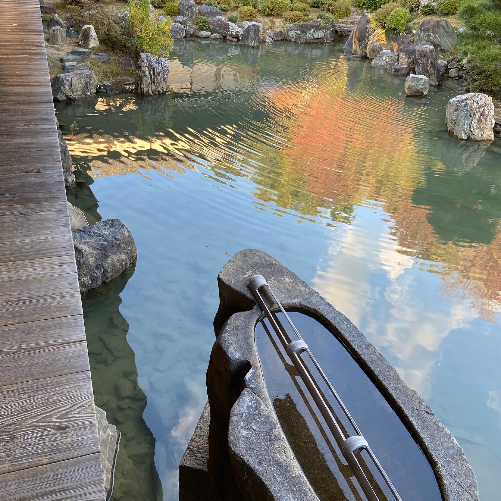 智積院の庭の池に映る紅葉と、手水鉢